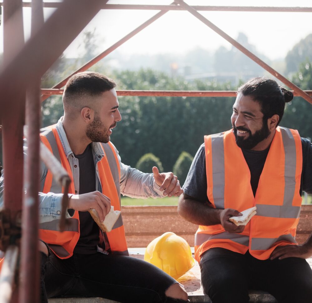 Happy Workers In Construction Site During Lunch Break