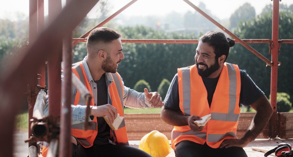 Happy Workers In Construction Site During Lunch Break
