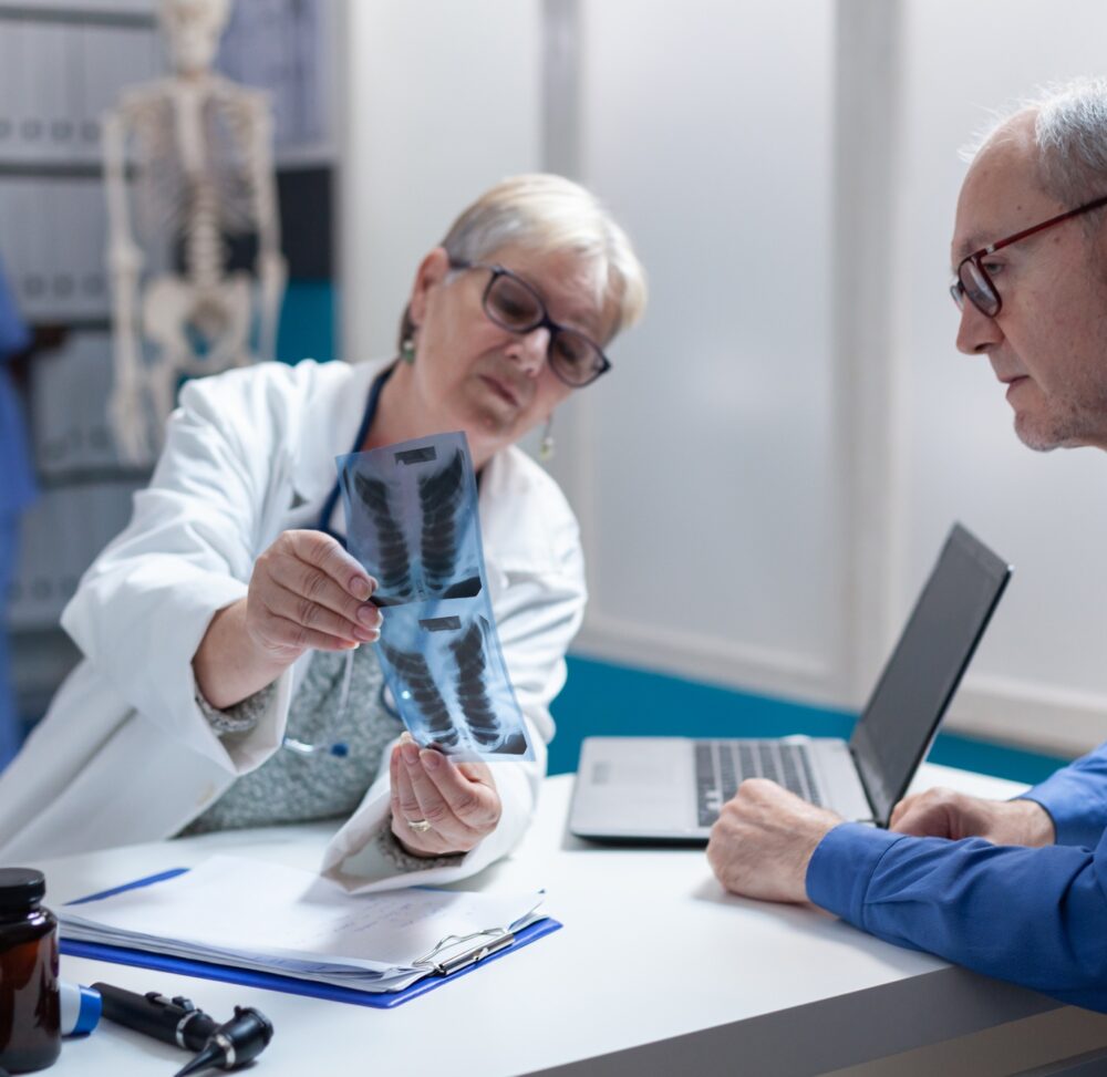 Medic and patient analyzing x ray scan exam results at consultation appointment
